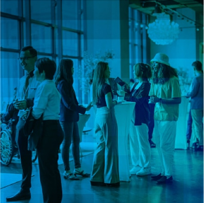 Group of people networking and talking at a professional event.