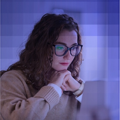 Woman with glasses studying on laptop for continuing education.