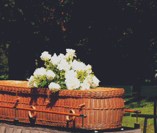 Green burial casket with flowers.